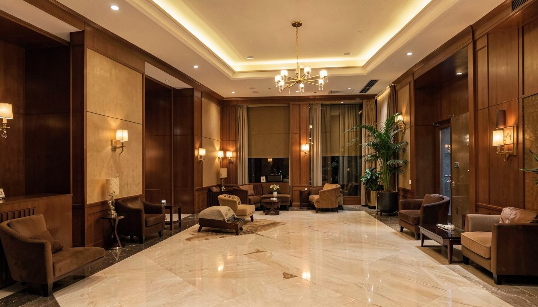 Warm brown and gold toned hotel lobby interior with soft ambient lighting, conveying a calm professional travel atmosphere
